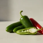 Grüne und rote Paprika auf heller Oberfläche; aufgeschnitten.