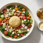 Bunter Salat mit Quinoa-Dom, Tomaten, Gurken und Feta.