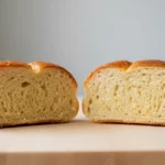 Aufgeschnittenes Brot liegt nebeneinander auf Holzbrett.