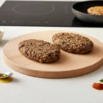 Zwei Haferkekse auf Holzbrett mit Zutaten.