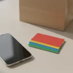 Smartphone neben farbigen Kartenstapel auf dem Tisch.