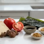 Käse, Tomaten, Nori-Blätter und Miso-Paste auf Küchenplatte.