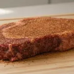 Rohes, gewürztes Steak auf Schneidebrett.