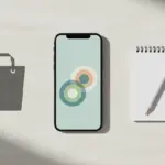 finke-blog881882: Smartphone, Notizblock und Einkaufstasche auf dem Schreibtisch.